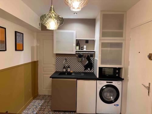 a kitchen with a washing machine and a washer at Appartement Bordeaux hyper centre in Bordeaux