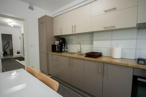 a kitchen with white cabinets and a counter top at DownTown Apartments in Rădăuţi