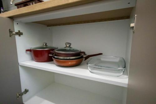 two pots and pans sitting on a shelf in a kitchen at DownTown Apartments in Rădăuţi