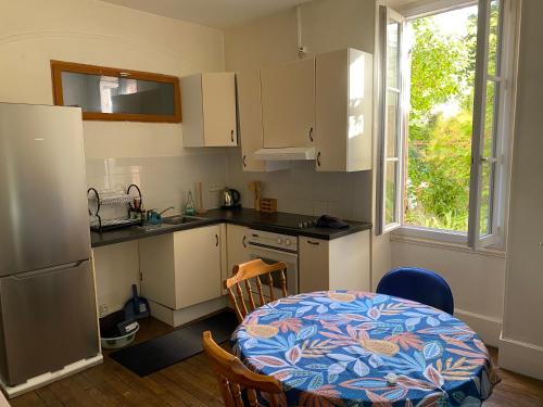 une petite cuisine avec une table et une table ainsi qu'une fenêtre dans l'établissement Appart Rez de jardin, à Dijon