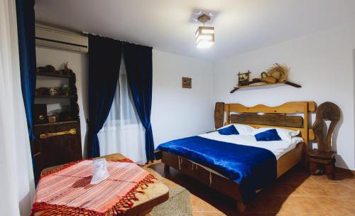 a bedroom with a bed with a blue comforter at Casa de la ghiol in Murighiol