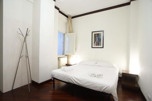 a white room with a bed and a window at Clorinda's rooms in Bari