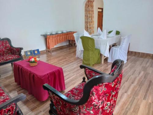 a living room with a table and chairs and a table and a tableablish at Sanda Sisila Guest House in Dambulla