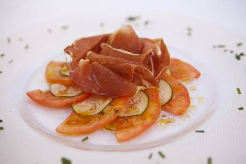 un piatto di cibo con carne e verdure sopra di L’Hermitage Hotel & Spa a Orient