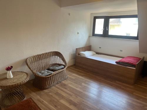 um quarto com uma cama, uma cadeira e uma janela em Rose Gasthaus em Crailsheim