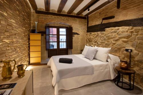 a bedroom with a large bed in a stone wall at Palacio del Marqués en Logroño con parking próximo in Logroño