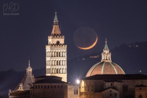a crescent moon rises over a city at night at Fabroniana apartment Elegant in Pistoia
