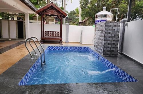 a swimming pool with blue tiles in a backyard at AliyaRoseMuslim Homestay in Ayer Keroh