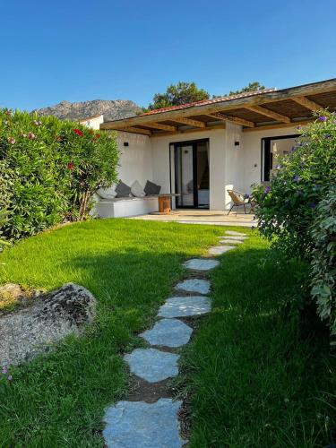 un jardin avec un chemin menant à une maison dans l'établissement Luxury beach front Villa & Private garden, à Lumio