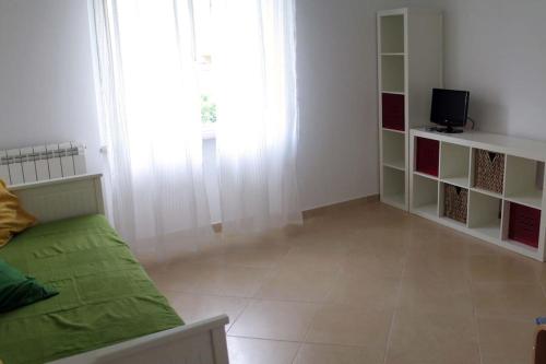 uma sala de estar com um sofá e uma televisão em Apartment with private Garden em Finale Ligure
