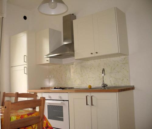una cucina con armadi bianchi e lavandino di Apartment with private Garden a Finale Ligure