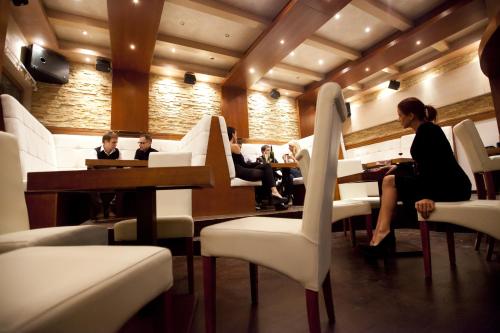 a group of people sitting at tables in a restaurant at Apart & Spa Zoned in Kopaonik