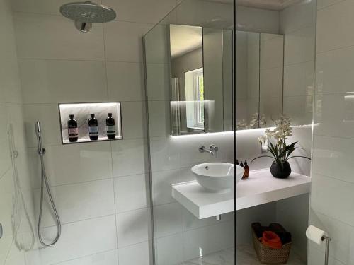 a white bathroom with a sink and a shower at Home in Wirral - Peaceful Contemporary Gem. in Wirral