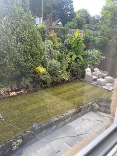 a view of a garden from a window at Home in Wirral - Peaceful Contemporary Gem. in Wirral