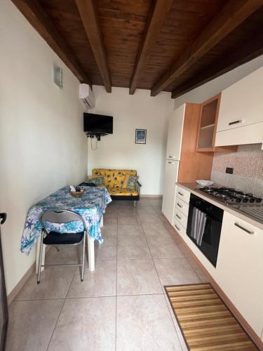 uma pequena cozinha com uma mesa e um sofá em Casa vacanze Arianna em Noto Marina