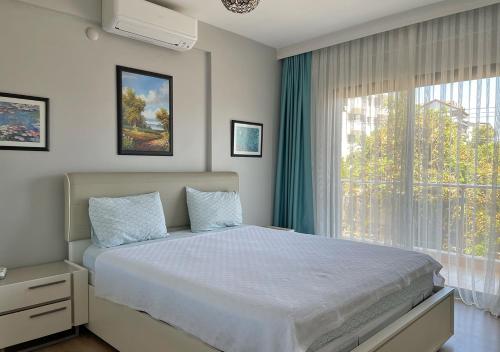 マルマリスにあるDeniz Manzaralı, Plaja 100 Metre, Luks Daire 3のベッドルーム1室(ベッド1台、大きな窓付)