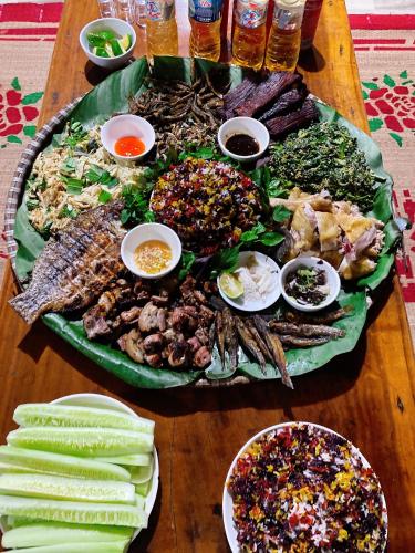 a table with a large plate of food on it at Homestay Chinh Bi in Yên Bái