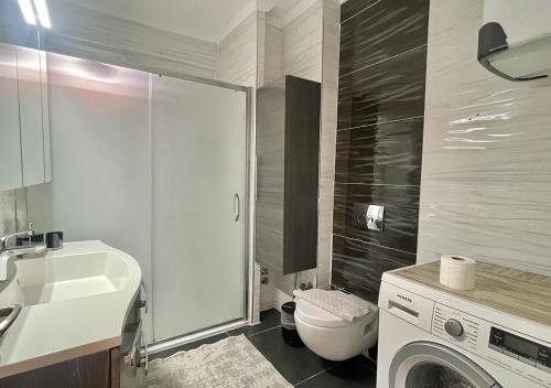 a bathroom with a toilet and a sink and a washing machine at Deniz Manzaralı, Plaja 100 Metre, Luks Daire 3 in Marmaris
