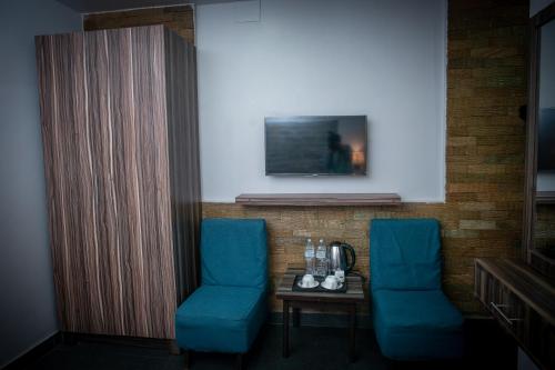 two blue chairs and a table in a room at Chautari Boutique Hotel in Pokhara