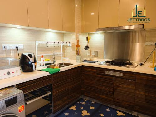Il comprend une cuisine équipée d'un évier et d'une cuisinière. dans l'établissement R&F Princess Cove By JettBros Johor Bahru, à Johor Bahru