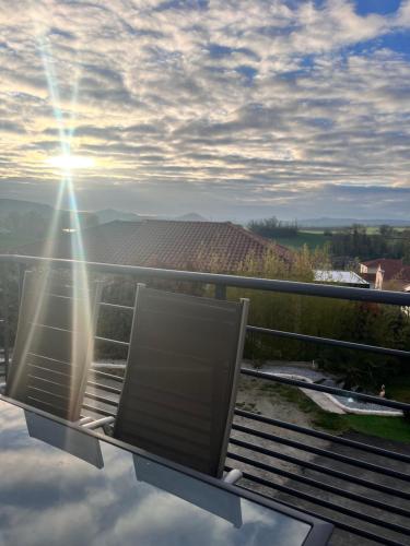 uma varanda com uma mesa de vidro com o sol a brilhar em chambre où suite privative accès indépendant em Pérignat-sur-Allier