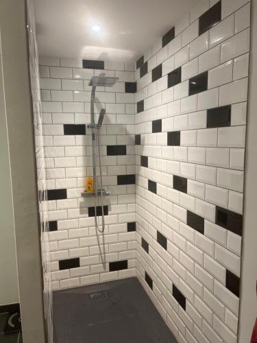 a bathroom with a shower with black and white tile at chambre où suite privative accès indépendant in Pérignat-sur-Allier