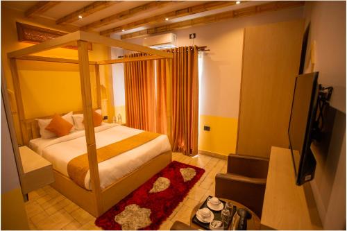 a bedroom with a canopy bed and a television at Chautari Boutique Hotel in Pokhara