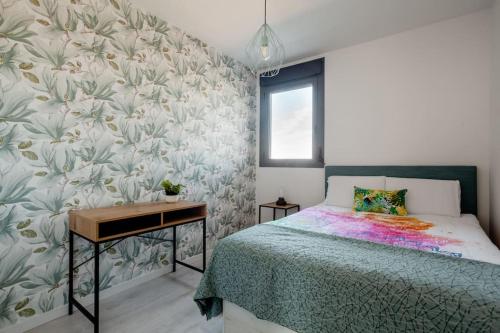 sypialnia z łóżkiem, stołem i ścianą w obiekcie Precioso apartamento en residencial con piscina w Walencji