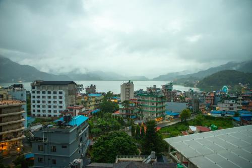 a city with buildings and a body of water at Chautari Boutique Hotel in Pokhara