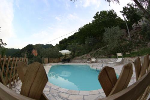 a large swimming pool with a wooden fence around it at Agriturismo Coldipietra in Cessapalombo