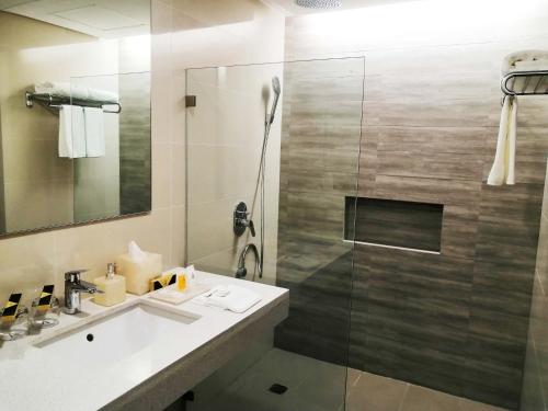 a bathroom with a sink and a shower at The Aurora Subic Hotel Managed By HII in Olongapo