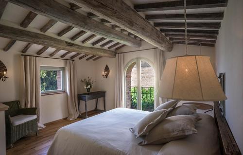ein Schlafzimmer mit einem großen Bett und einem großen Fenster in der Unterkunft Villa Mandorlo - Pomaio Wines & Hospitality in Arezzo