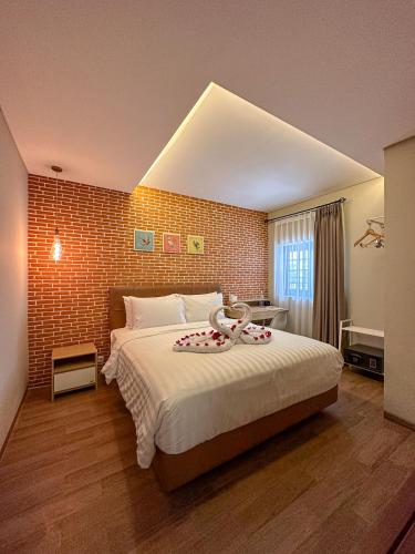 a bedroom with a large bed and a brick wall at Lugano Arte Homestay in Jakarta