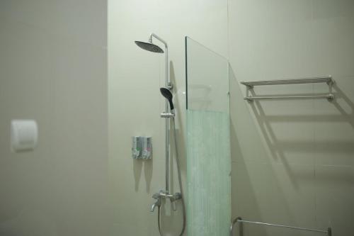 a shower in a bathroom with a glass door at WISMA KUSUMA HOTEL in Kedungdowo
