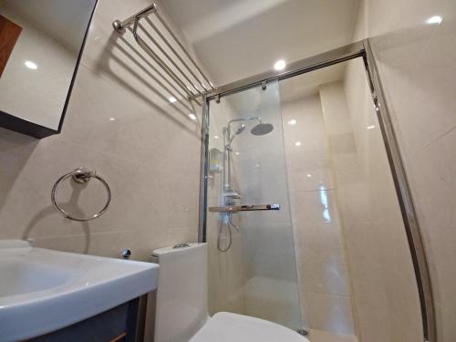 La salle de bains est pourvue d'une douche, de toilettes et d'un lavabo. dans l'établissement Gabs CozyHomes at MegaTower IV Condo, City Center Baguio, à Baguio