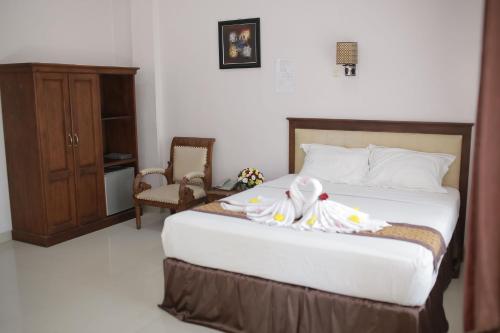 a bedroom with a bed with towels on it at WISMA KUSUMA HOTEL in Kedungdowo