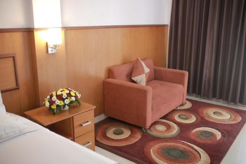a hotel room with a chair and a bed at WISMA KUSUMA HOTEL in Kedungdowo