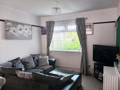 a living room with a couch and a window at House of Shiloh in Sheffield