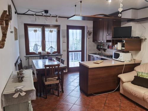 una cucina e un soggiorno con divano e tavolo di Il giardino sulle Piste a Prato Nevoso