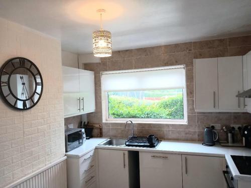 a small kitchen with a sink and a window at House of Shiloh in Sheffield