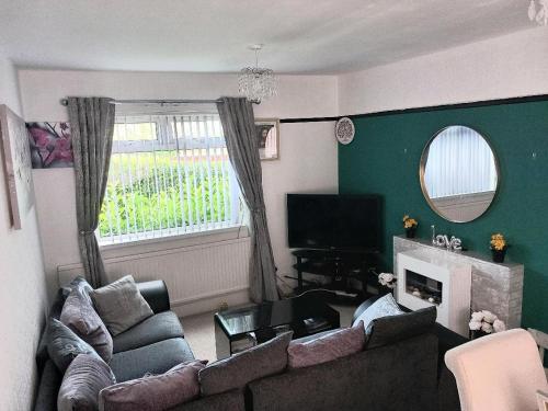ein Wohnzimmer mit einem Sofa und einem Kamin in der Unterkunft House of Shiloh in Sheffield