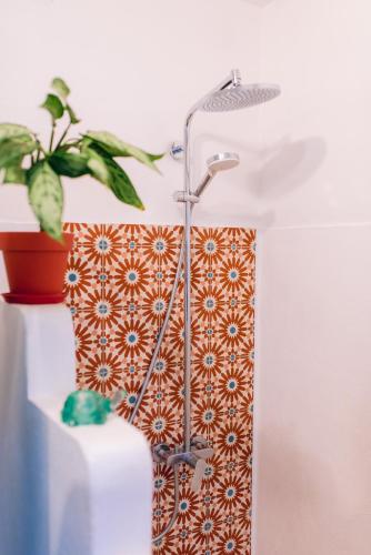 a shower head in a bathroom with a potted plant at Tree Lodge Mauritius Villa in Argy