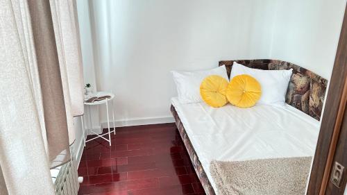 uma cama com duas almofadas amarelas em cima em Arlan apartments em Almaty