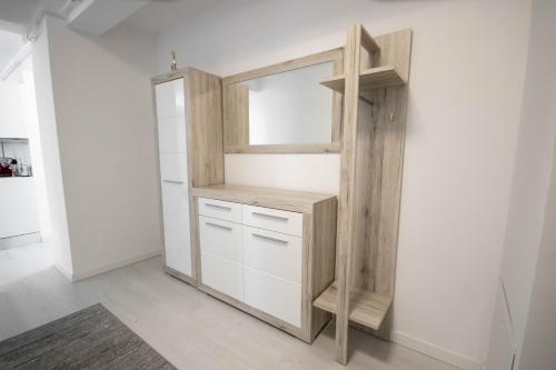 a closet with white cabinets and a mirror at DownTown Apartments in Rădăuţi