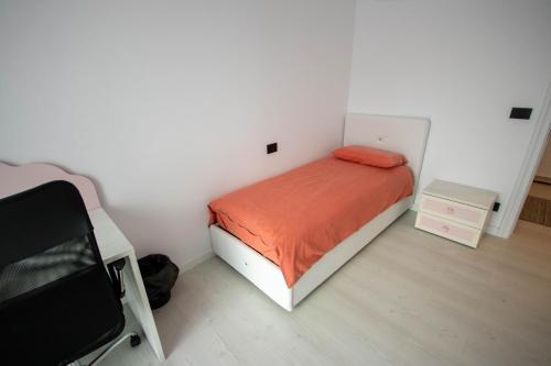 a small bedroom with a bed with an orange blanket at DownTown Apartments in Rădăuţi