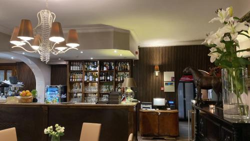 a restaurant with a bar with flowers on the counter at Hotel Kresowianka in Konin