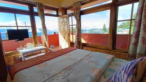 a bedroom with a bed and a large window at Rambler's Nesting Homestay in Darjeeling