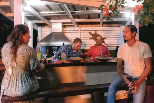 a group of people standing around a counter in a kitchen at Tree Lodge Mauritius Villa in Argy
