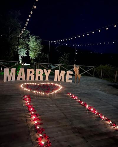 a sign that says marry me with red lights at Porto Gumati in Kutaisi