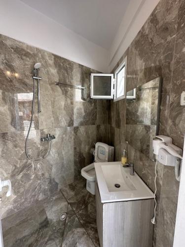 a bathroom with a shower and a sink and a toilet at Jona Rooms in Himare